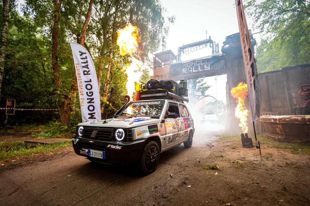Cyberpandino al Mongol Rally: Fiat Panda da spedizione in movimento, con fiamme e banner CYBERPANDINO